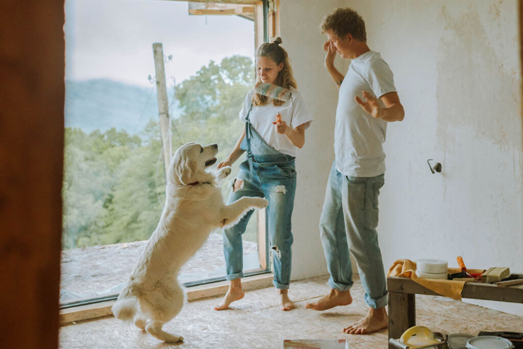 pareja con su perro pintando la casa
